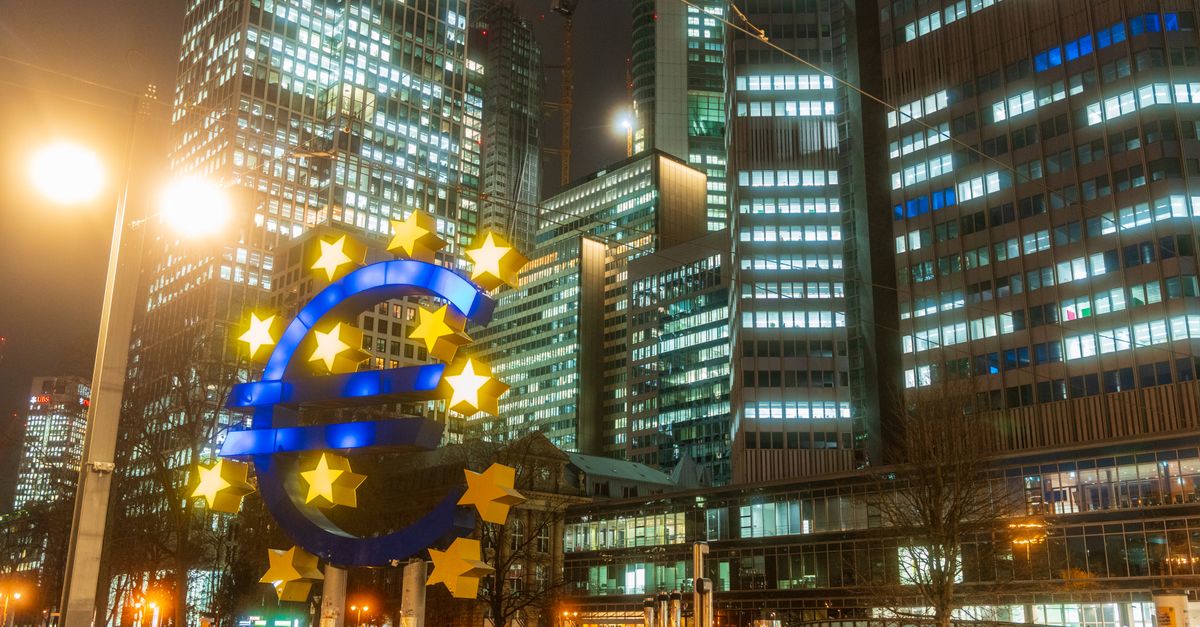 Night view of the iconic Euro sculpture in Frankfurt's bustling financial district.